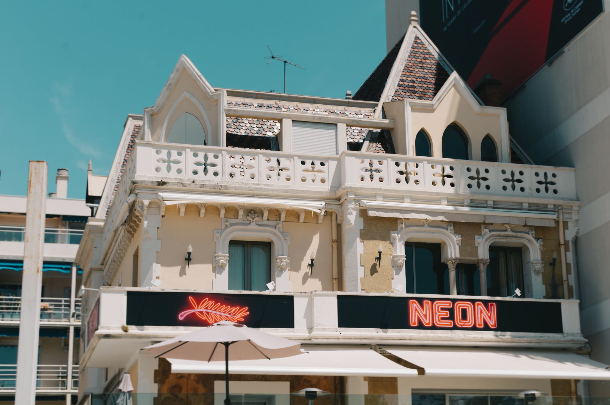 A classic French building with neon signage in Cannes, Provence-Alpes-Côte d'Azur, France.